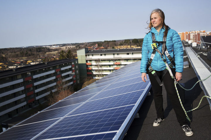 Woman standing on roof with solar panels