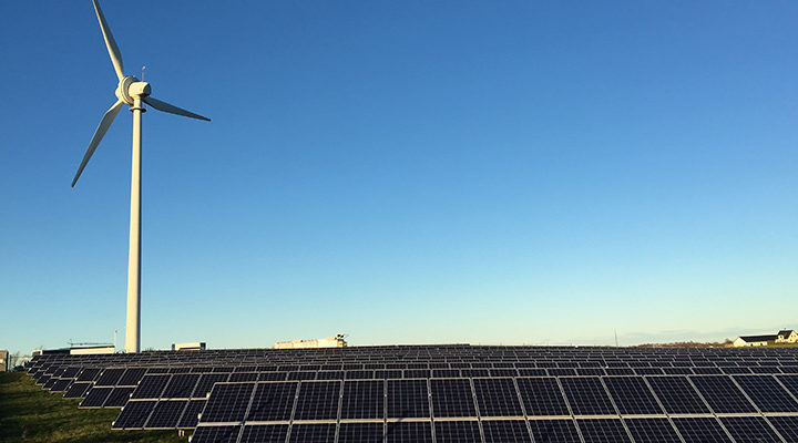 Wind power plant and solar panels on blue sky