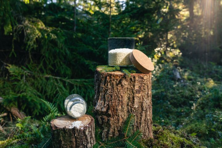 Containers holding the cellulose-based adsorbent in a forest backdrop